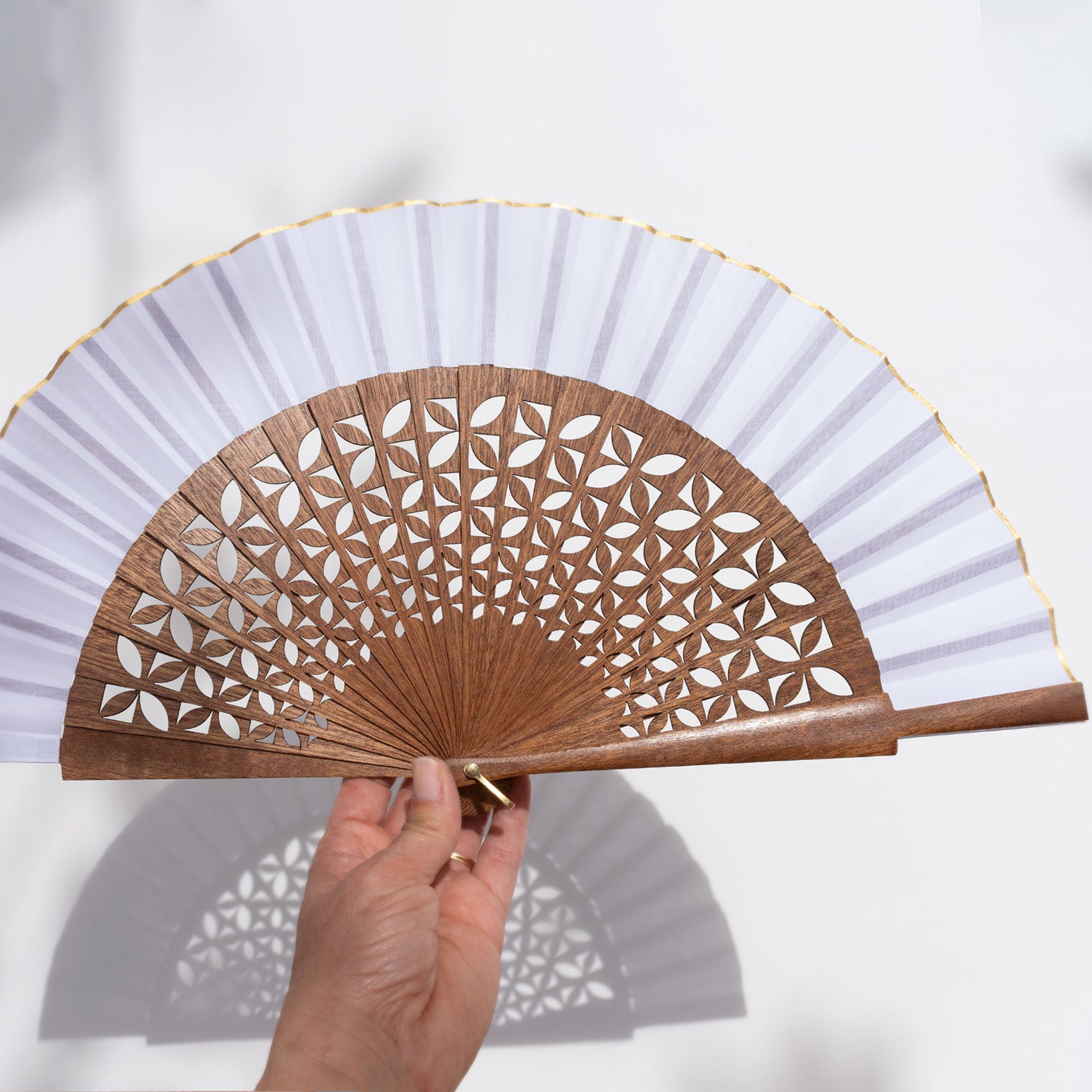 Detalle de abanico calado en madera de sipo, una pieza de artesanía española que une tradición y diseño minimalista